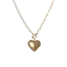 Necklace with heart-shaped gold pendant and pearl chain on a white background