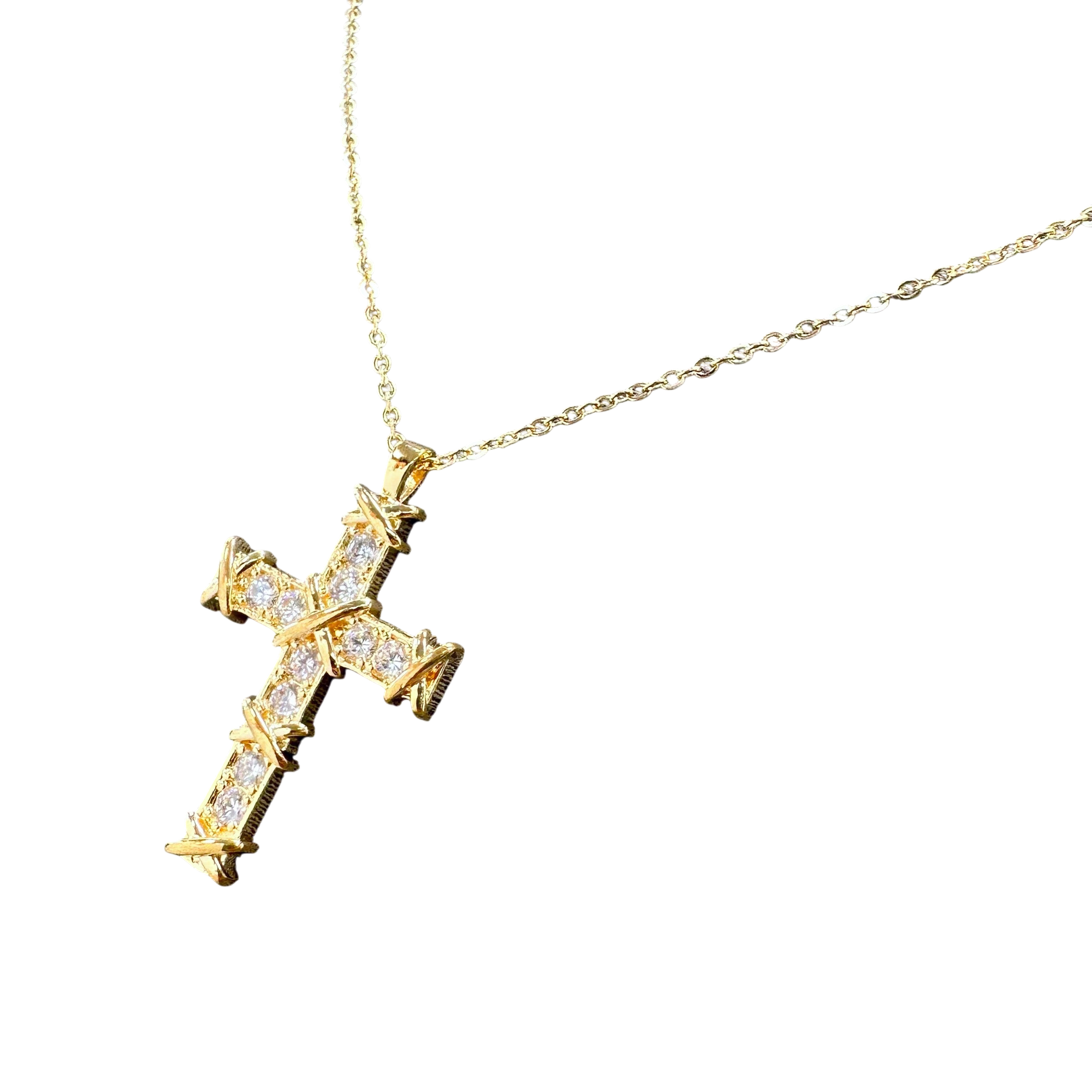 Gold cross necklace with diamonds on a white background