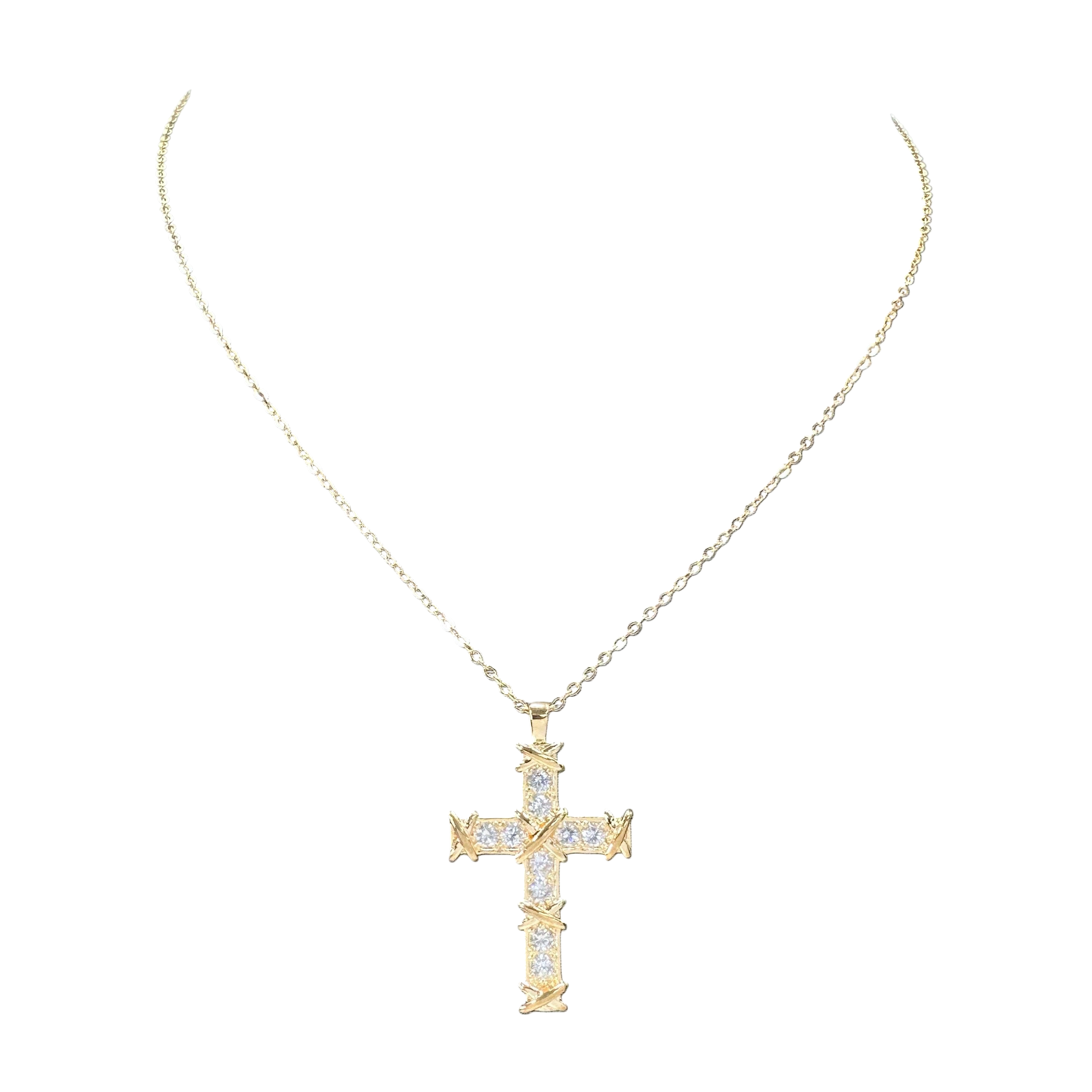 Gold cross necklace with diamonds on a white background