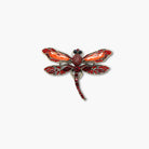 Red dragonfly-shaped brooch on a white background