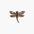 Decorative dragonfly brooch with gemstones on a white background