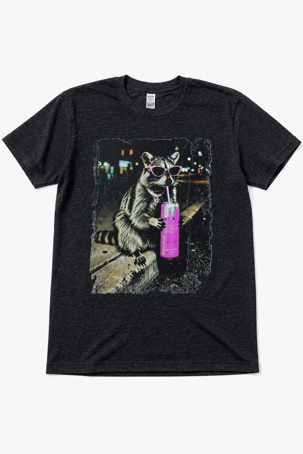 A dark heather gray short-sleeve t-shirt featuring a graphic print of a raccoon wearing sunglasses and holding a purple drink, displayed against a light gray background.