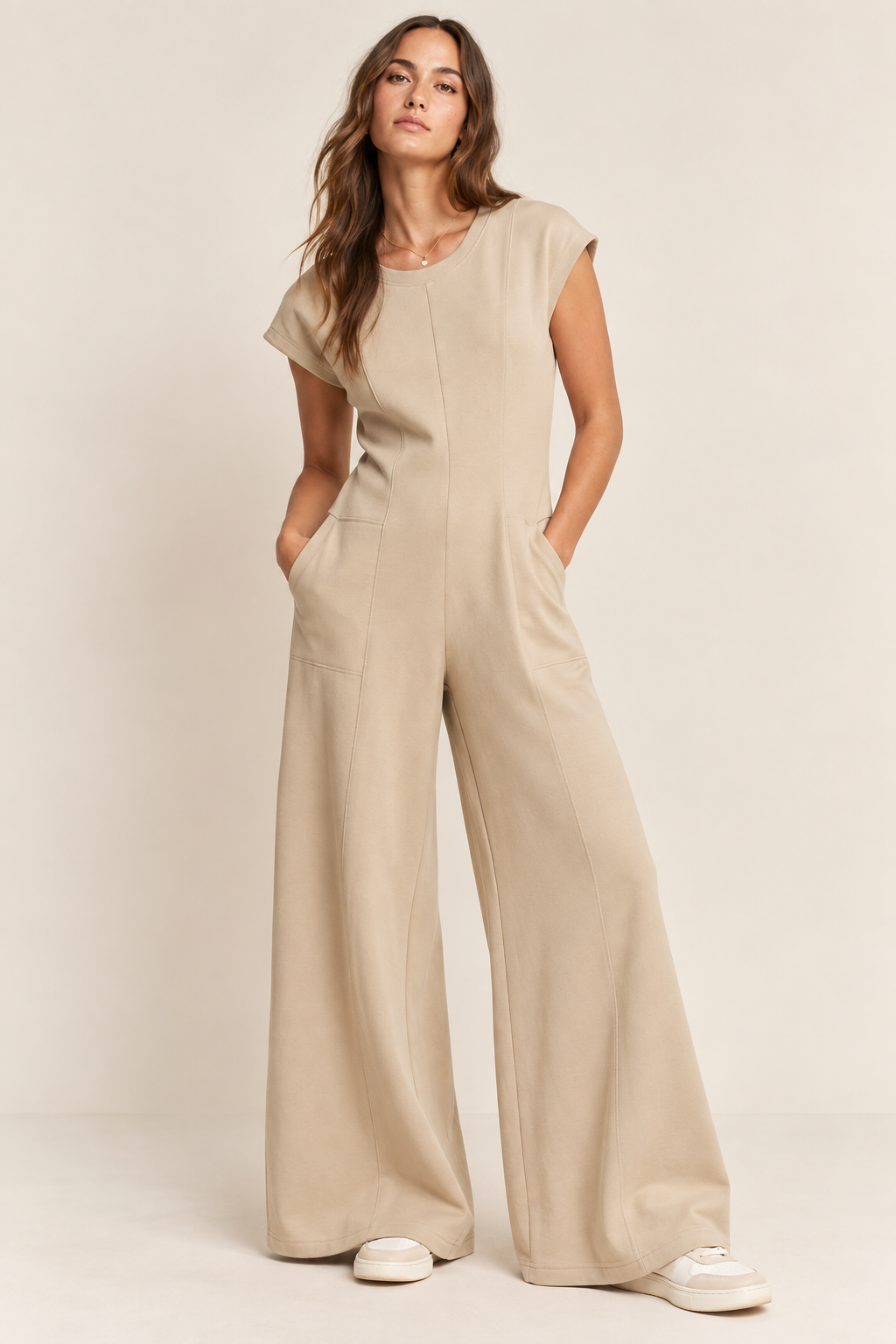 Model wearing a short-sleeve wide-leg jumpsuit with front seam detailing and side pockets