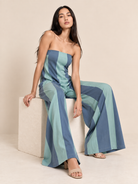 Model wearing a strapless wide-leg jumpsuit with vertical stripe detailing and side pockets