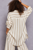 Ivory and white striped button-down shirt with rolled sleeves, layered over a white lace-trim camisole and paired with matching striped pants, styled on a curly-haired model.