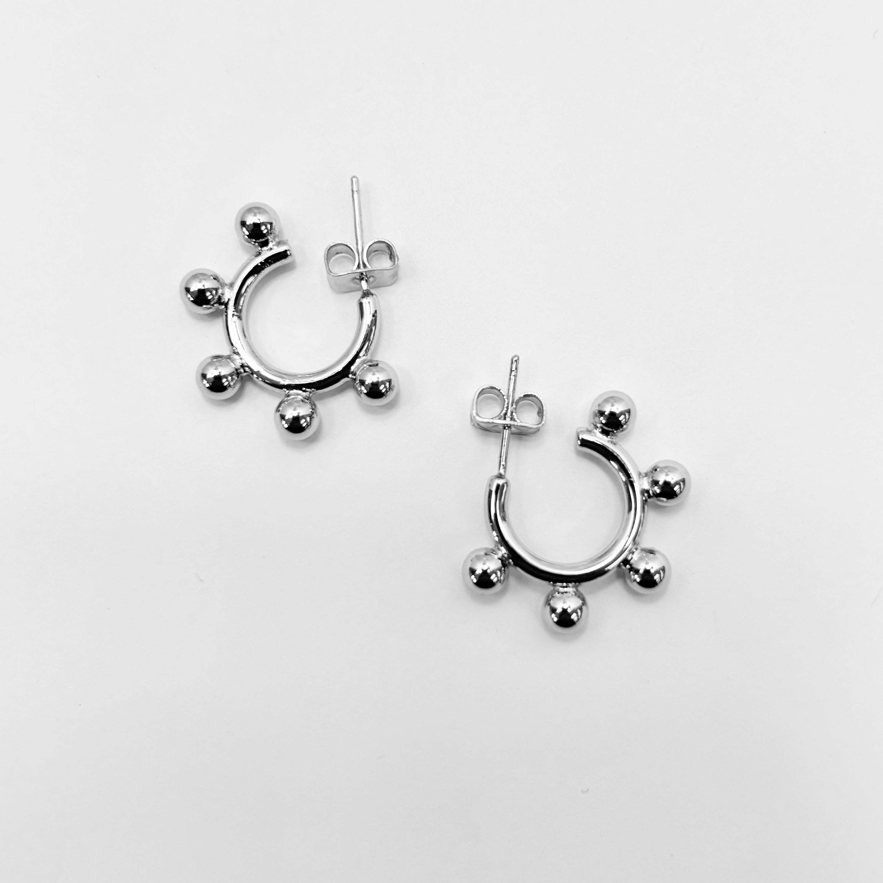 A pair of gold-colored hoop earrings with small dangling embellishments.