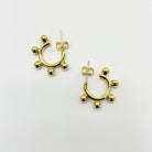 A pair of gold-colored hoop earrings with small dangling embellishments.