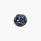 Jewelry item with blue gemstone and black metal setting on a white background