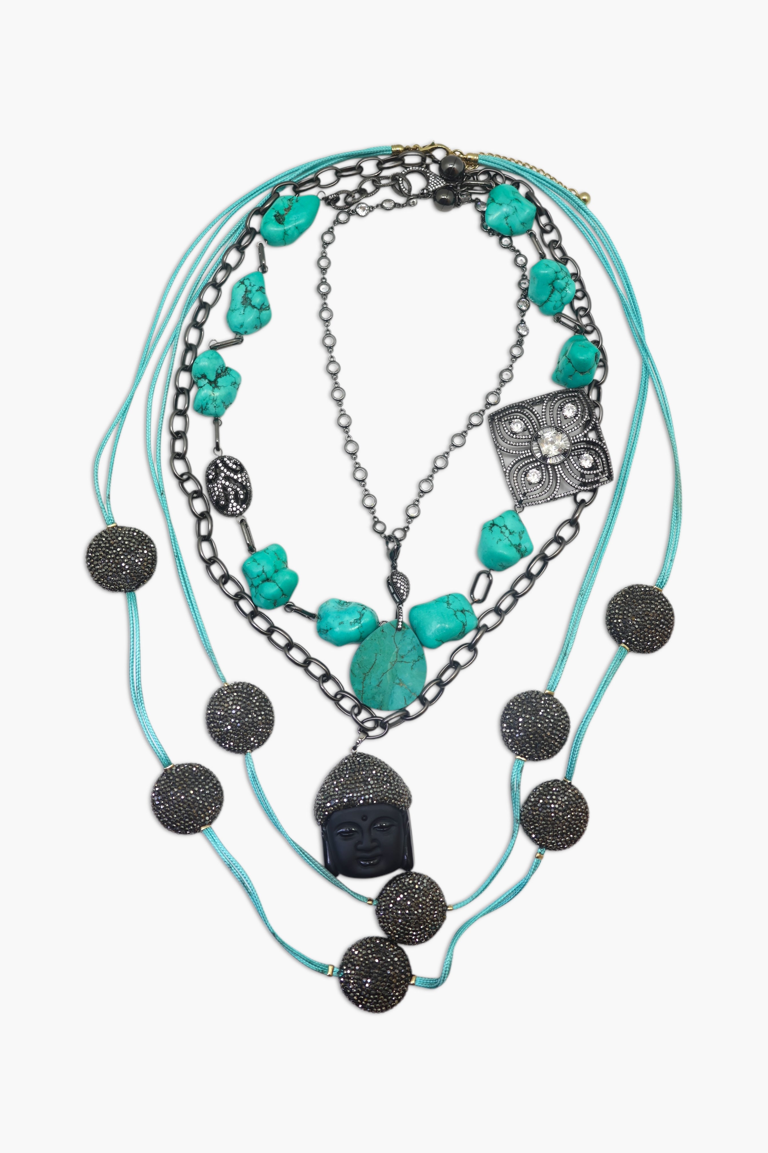 A piece of jewelry with multiple strands, featuring black coins, turquoise stones, and a watch-like component