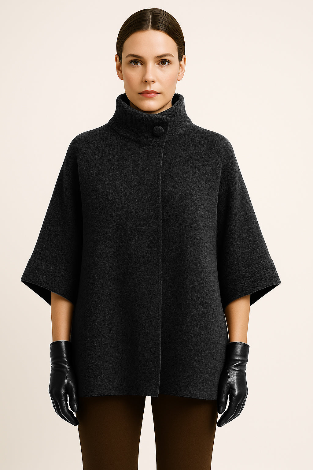 Woman wearing a black poncho and gloves on a beige background