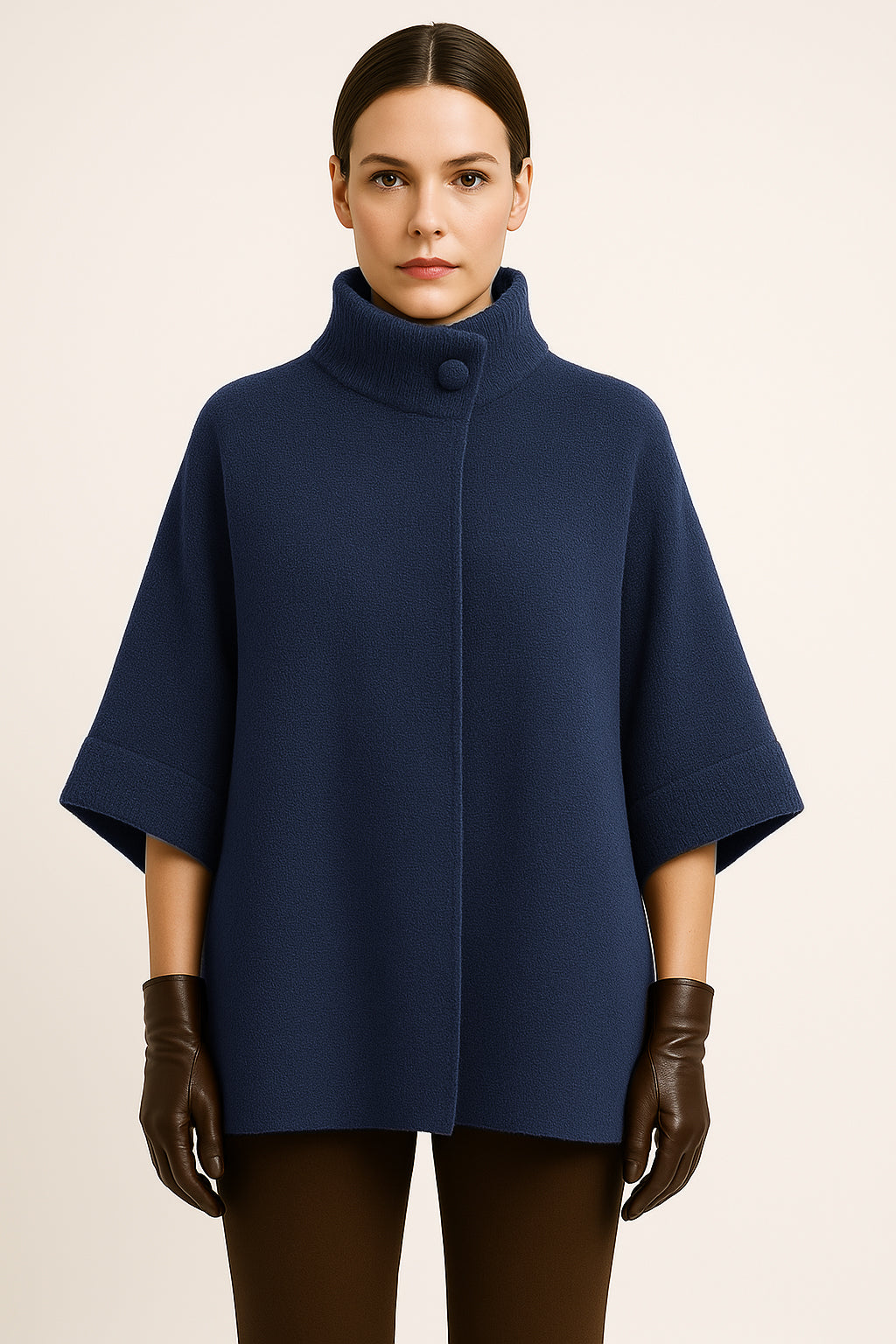 Woman wearing a blue poncho and brown gloves on a beige background