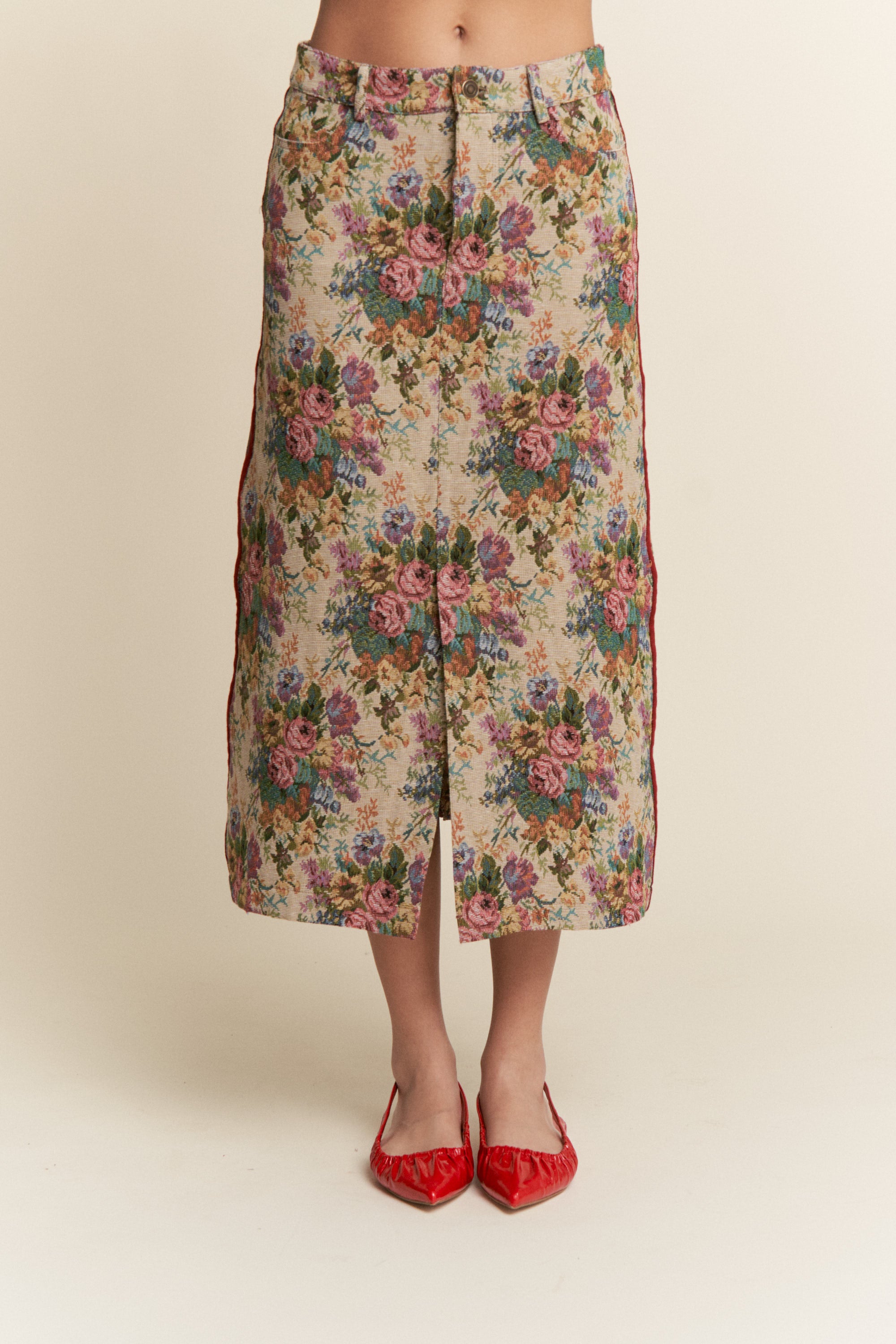 Floral patterned skirt worn by a person on a beige background