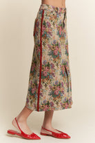 Floral skirt with red zipper and red shoes on a beige background