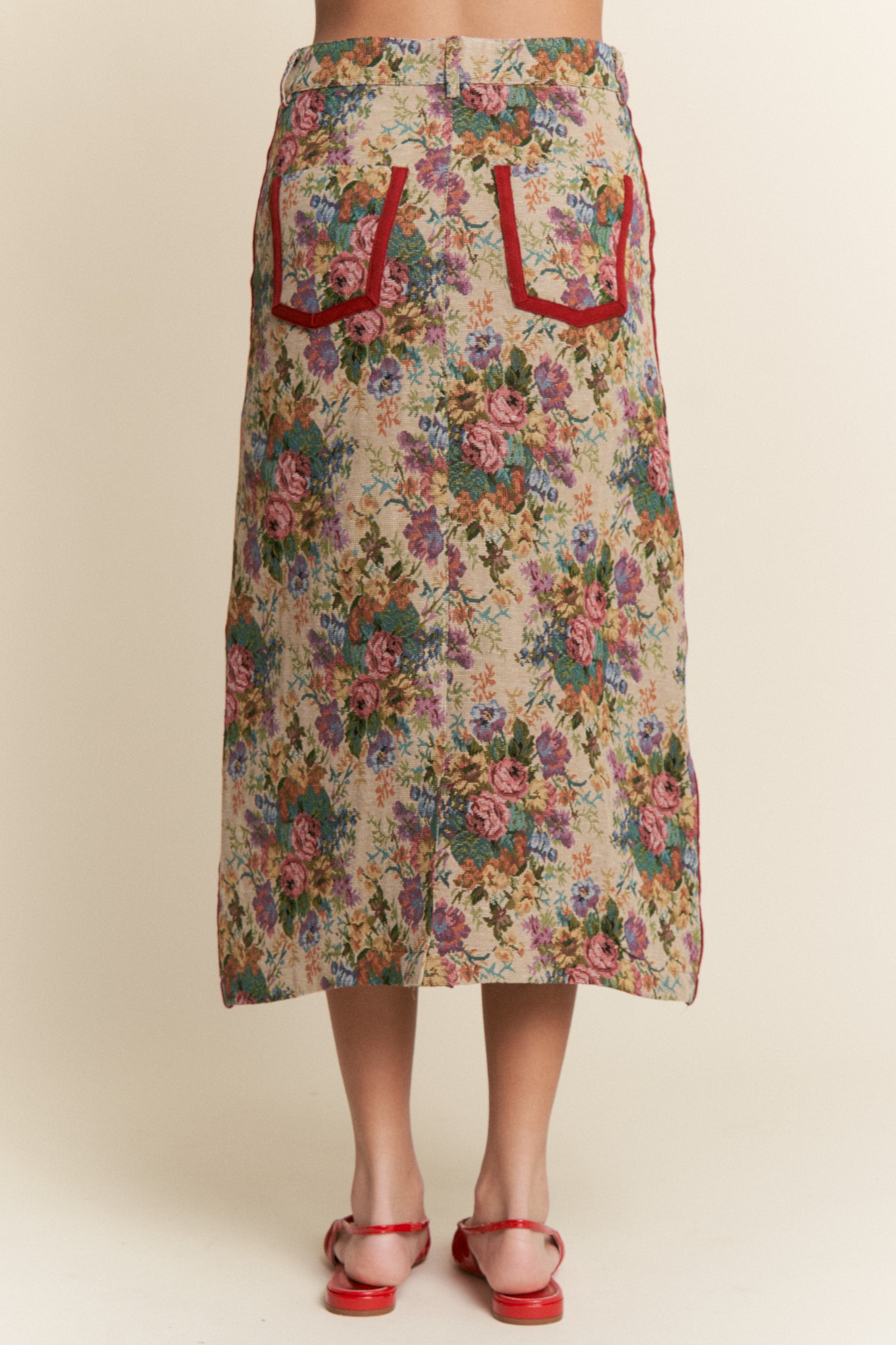 Floral skirt with red pocket details on a beige background