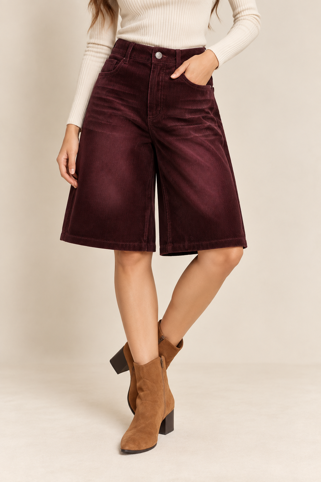 Model wearing high-waisted corduroy Bermuda shorts with wide-leg fit, front pockets, and button closure