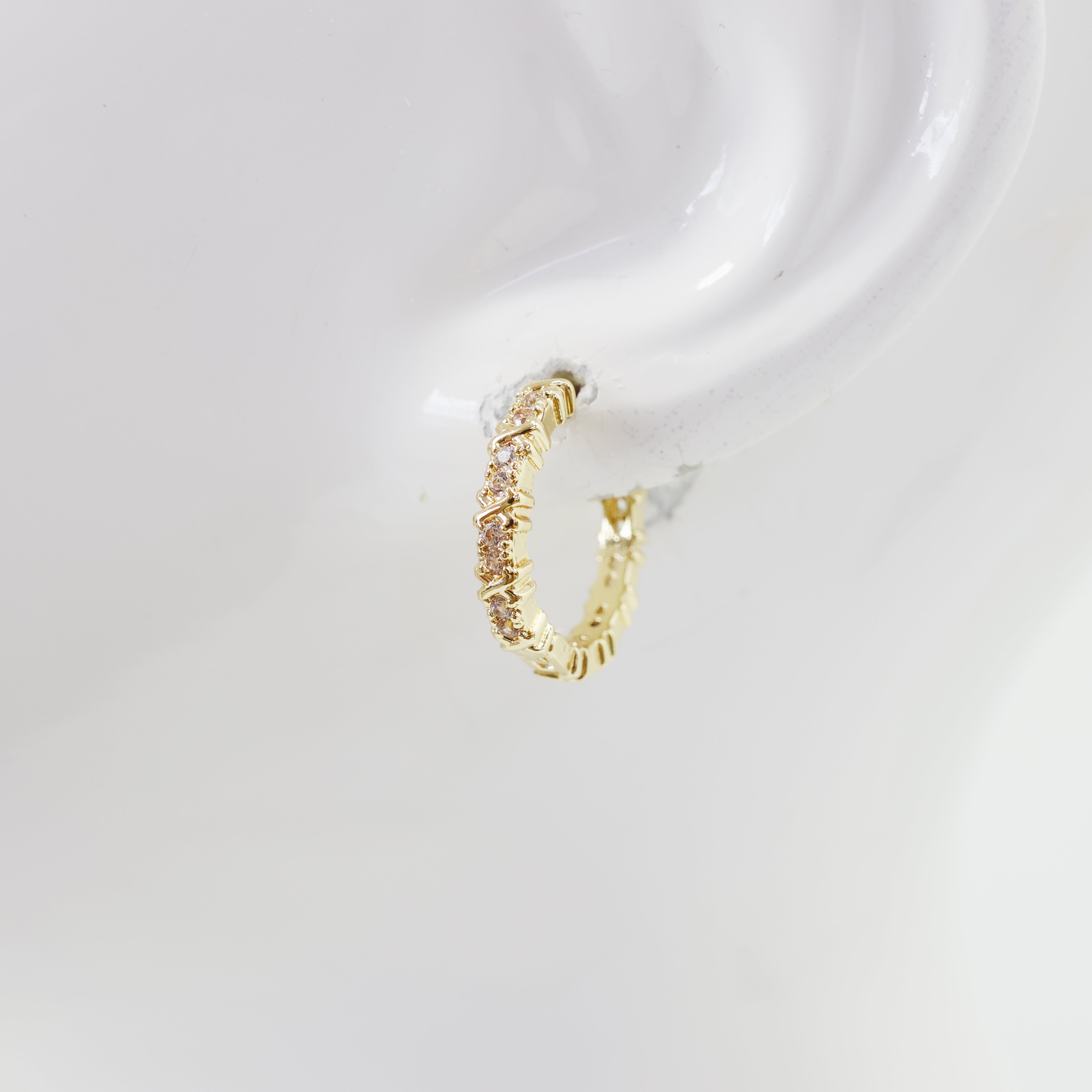 A pair of hoop earrings with a textured surface on a white background.
