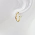 A pair of hoop earrings with a textured surface on a white background.