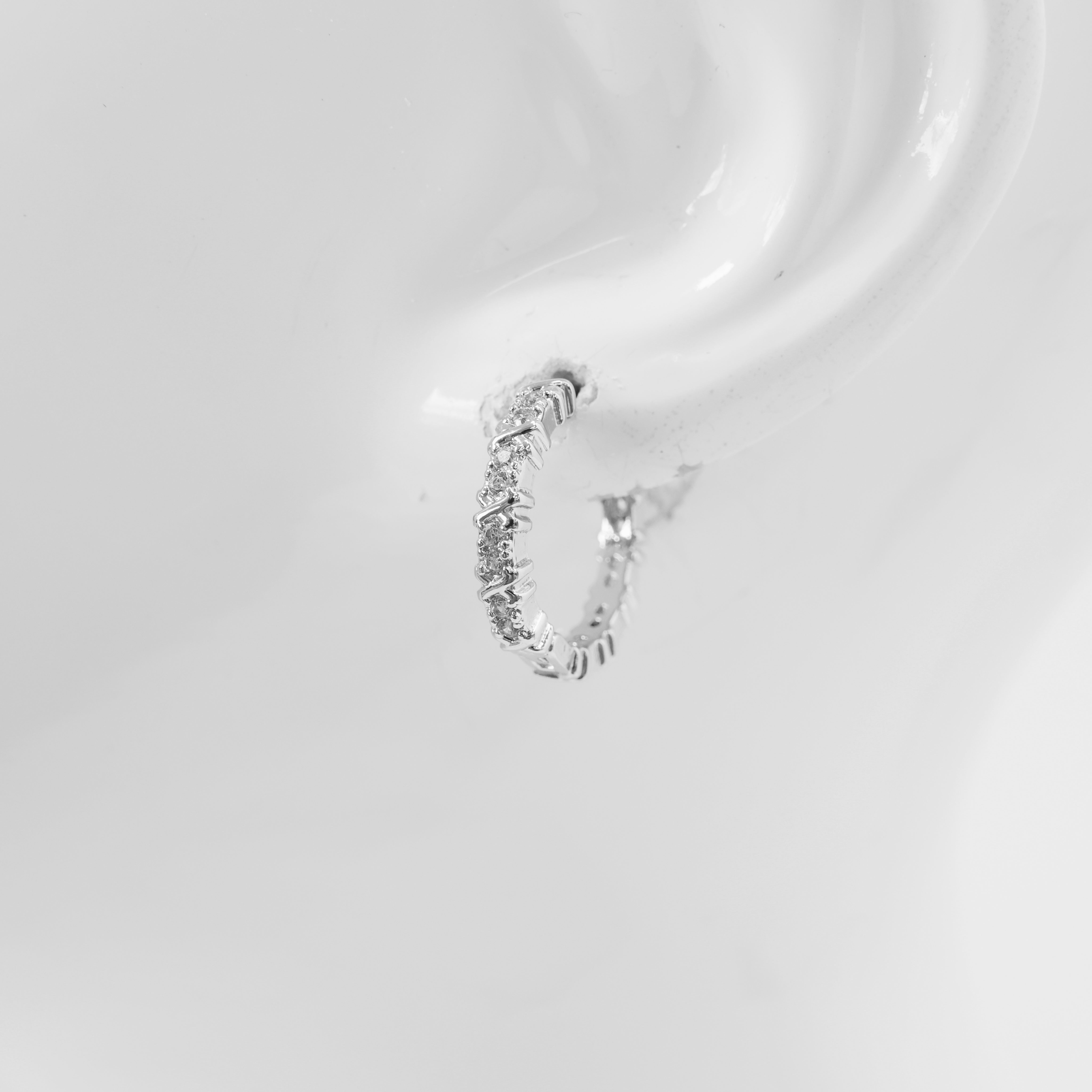 A pair of hoop earrings with a textured surface on a white background.