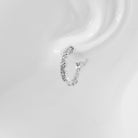 A pair of hoop earrings with a textured surface on a white background.